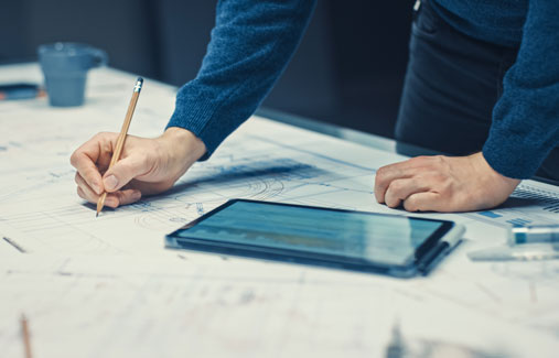 A person going over blueprints on a table