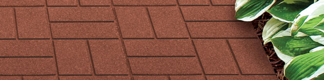 A rubber paver walkway with landscaping at the edges.